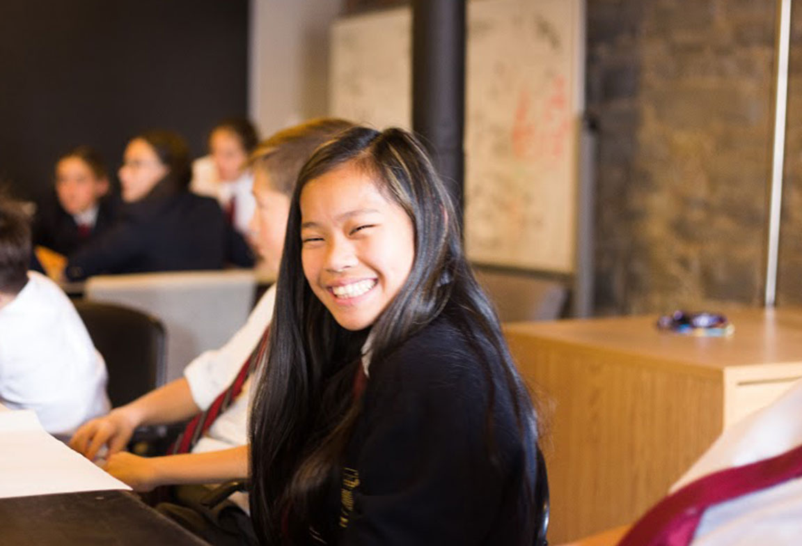 Picture of a student smiling during class.
