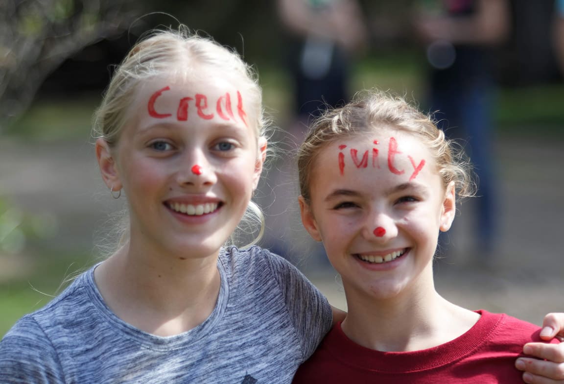 Picture of two students with Creativity House face paint at an outdoor House activity