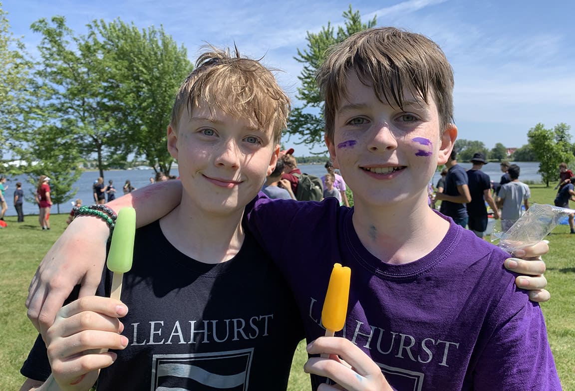 Picture of two students holding popcycles, and wearing House t-shirts at an outdoor House activity