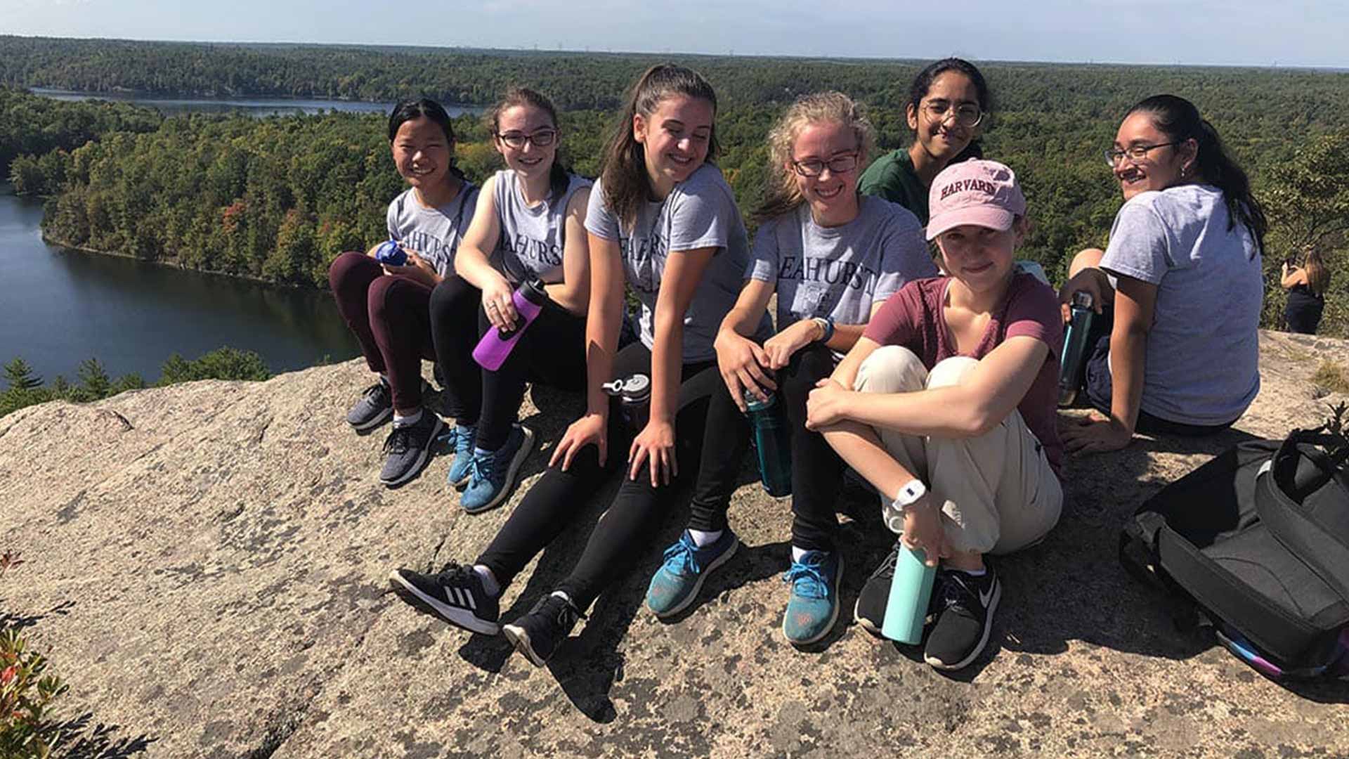 Picture of a group students sitting on top of a mountain