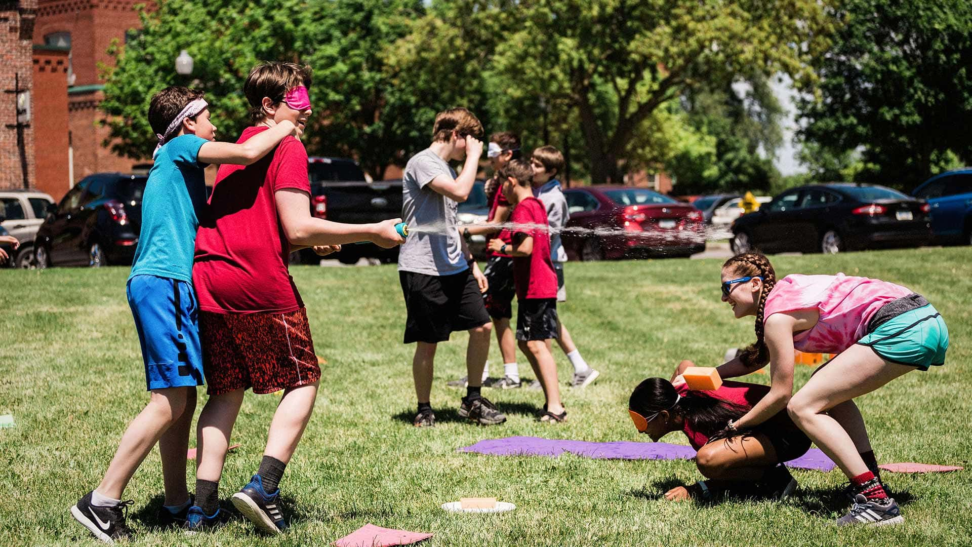 Picture of students taking part in a House activity outdoors where one student is spraying another student with water