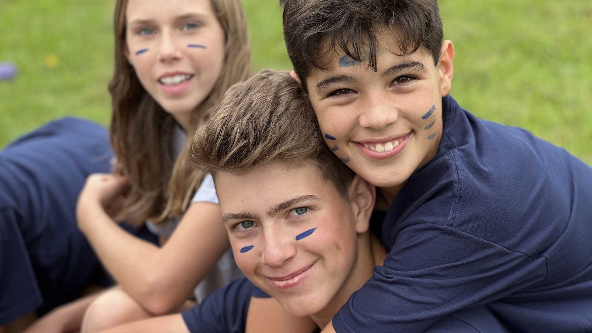 Picture of three students wearing House Flow t-shirts and smilling