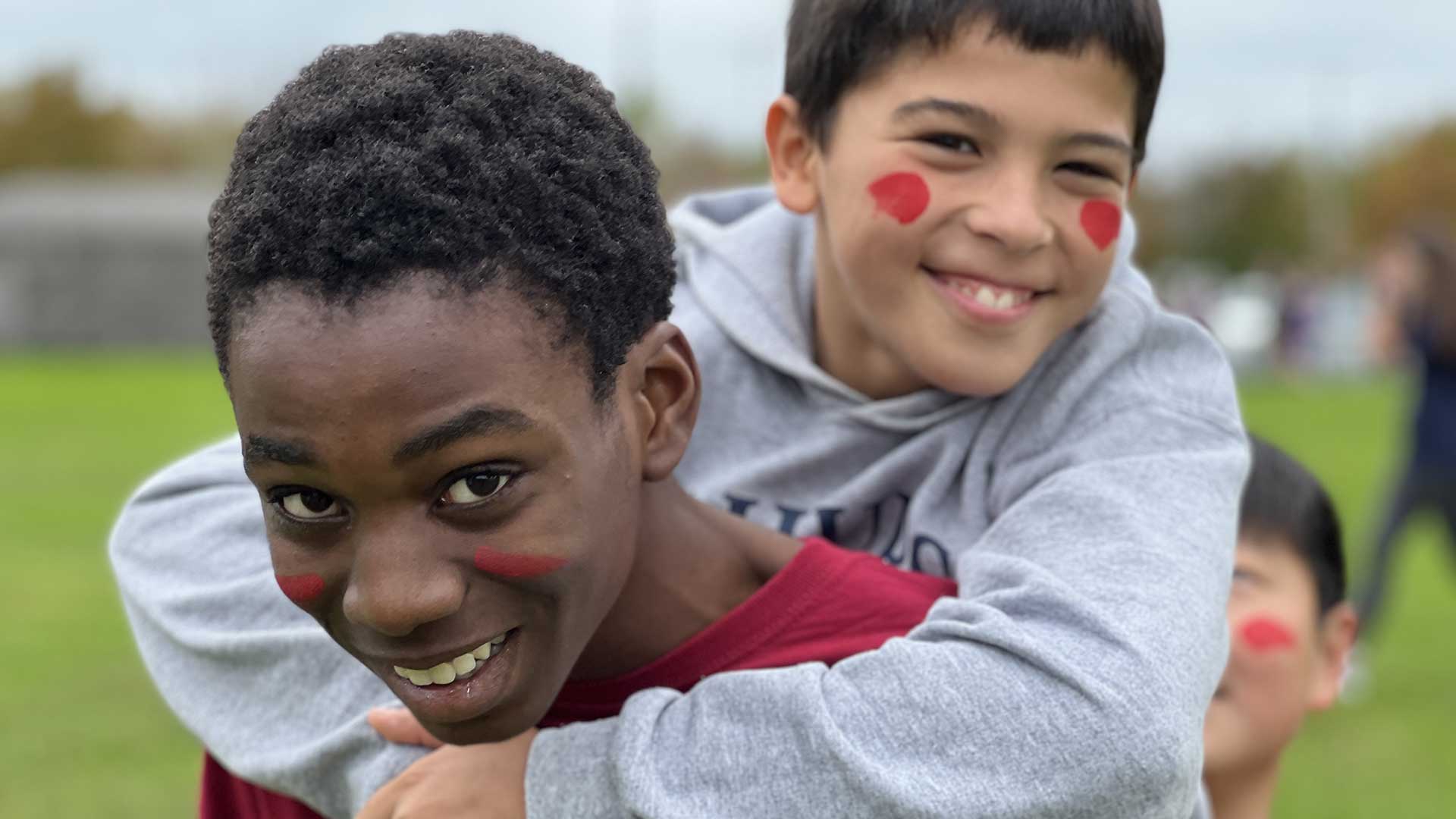 Picture of a student piggy backing on another student outdoors