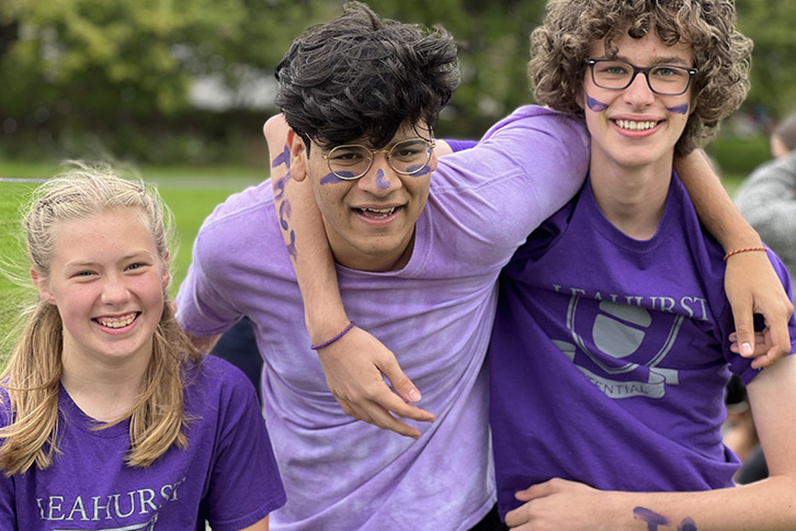 Picture of three students wearing a House Potential purple t-shirt outdoors