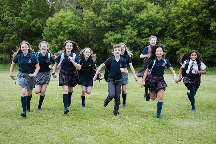 Picture of nine students running in the school yard
