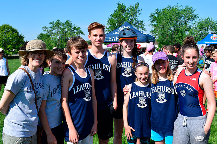 Picture of the head of school with a student at an athletic event outdoors..