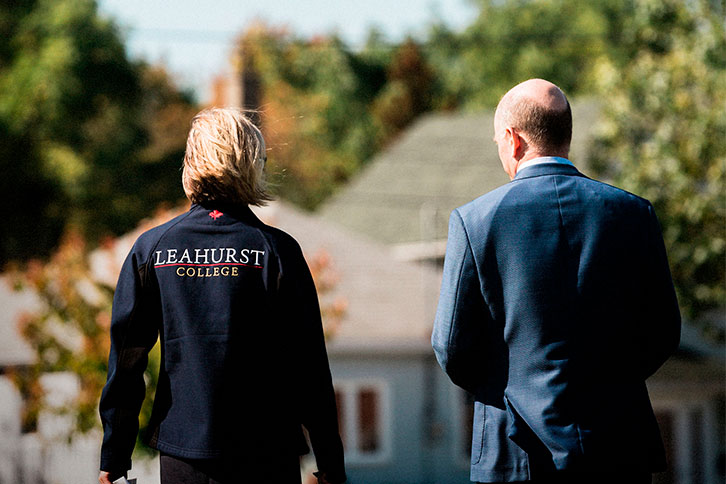 Picture of the head of school walking with a colleague outdoors.