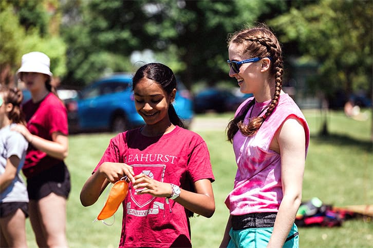 Picture of two students attending a House event outdoors