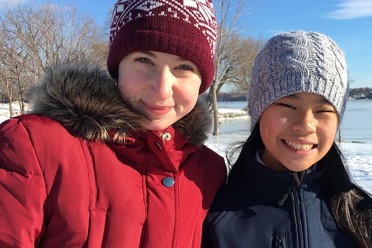 Picture of two students posing for a picture outdoors during the winter