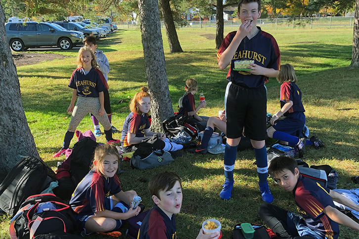 Picture of junior school students eating outdoors after an athletic event