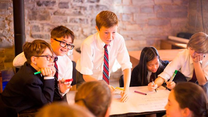 Picture of five students working together on a project in a classroom