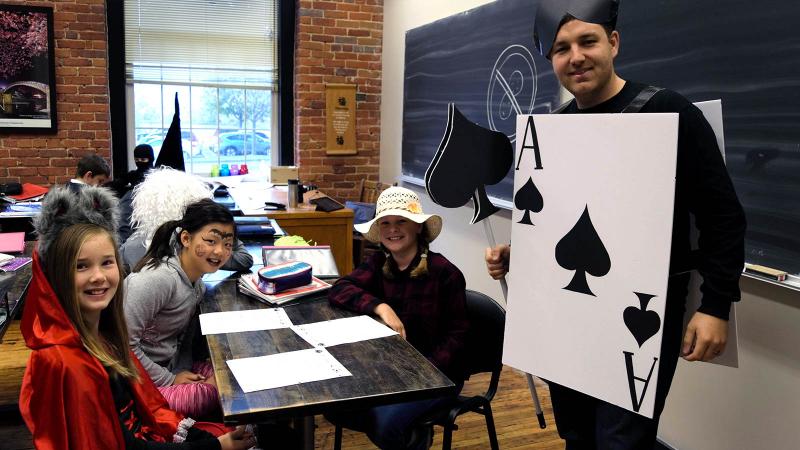 Picture of students in costume with a teacher dressed up as an ace of cards