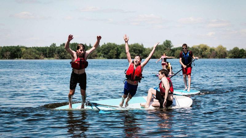 Picture of students jumping of a paddle into a lake