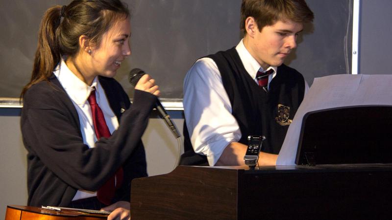 Picture of a student playing the piano and a student signing