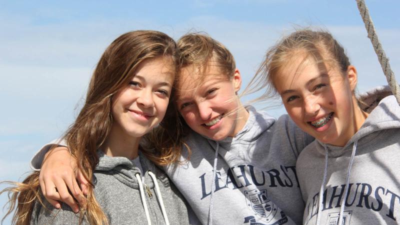Picture of three student sailing and smilling