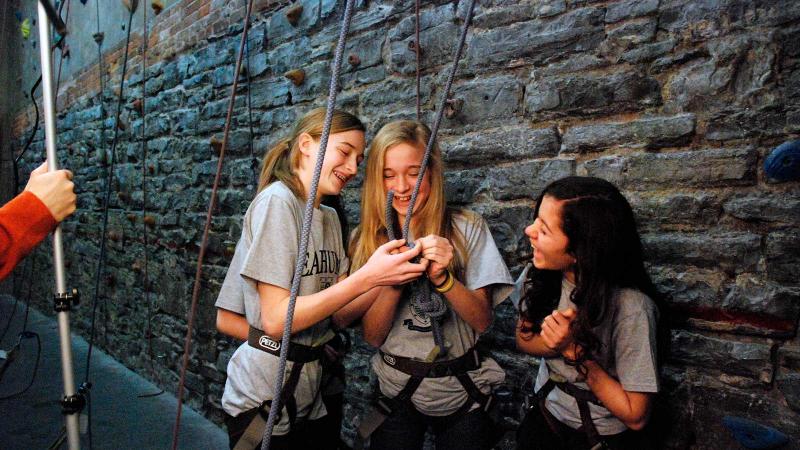 Picture of students next to a rock climbing wall