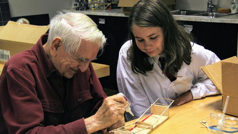 Picture of a student working on a project with an elderly person
