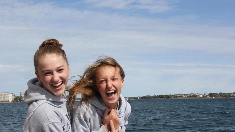 Picture of two students outdoors in front of water