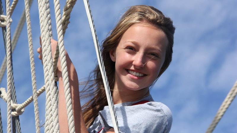 Picture of a student on a sail boat smiling