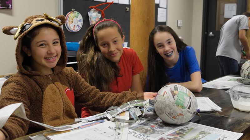 Picture of three student doing paper mache