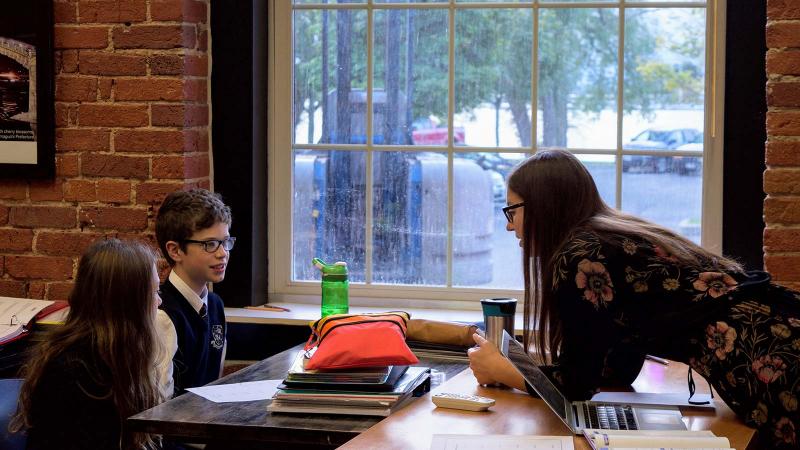 Picture of two students with a teacher in a classroom