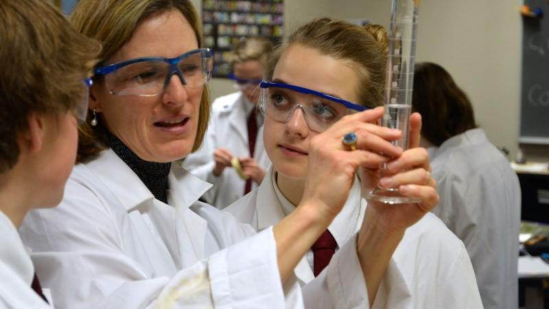 Picture of two students in a science lab with a teacher