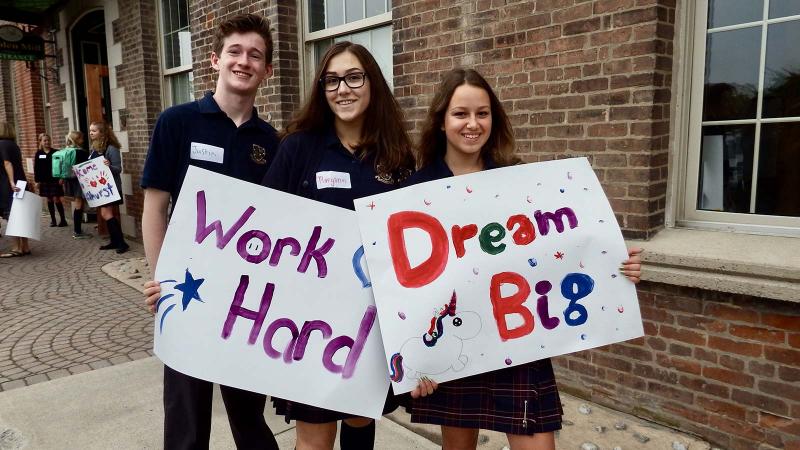 Picture of students holding up school spirit signs