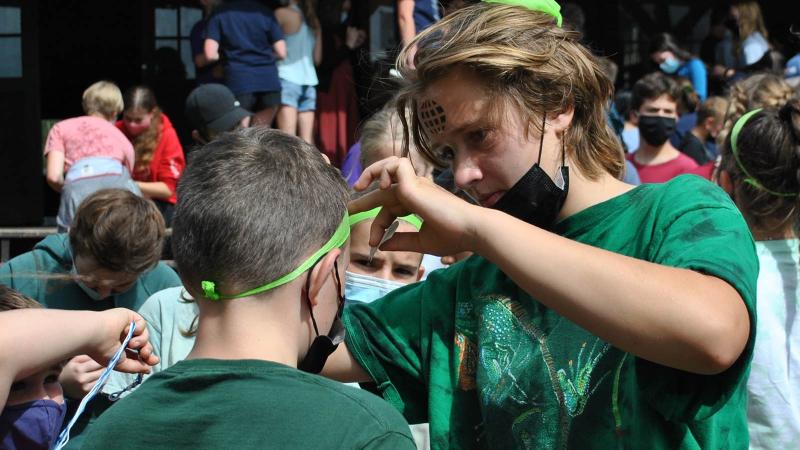 Picture of a faculty member applying face paint on a students face