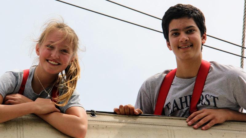 Picture of two students posing for a photo on a sailing boat