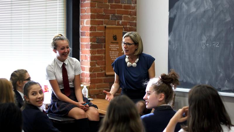 Picture of the Head of School talking to a full classroom