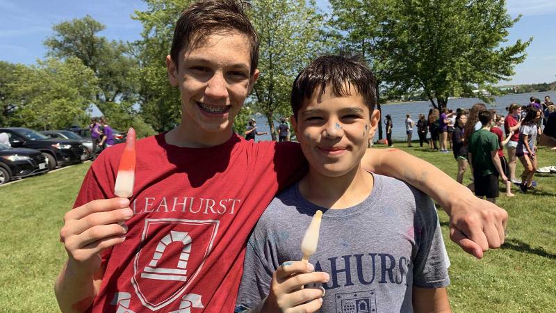 Picture of two students posing together holding popcycles outdoors during a House activity