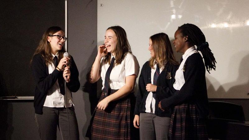 Picture of five student presenting in front of the class smiling