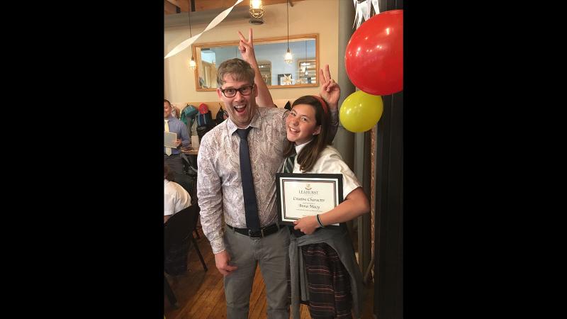 Picture of a teacher and student with a certificate in her hands