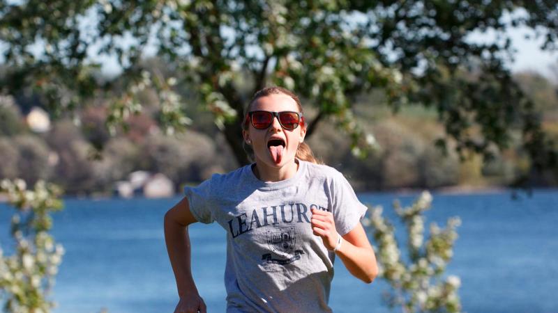 Picture of a student running and sticking out their tongue