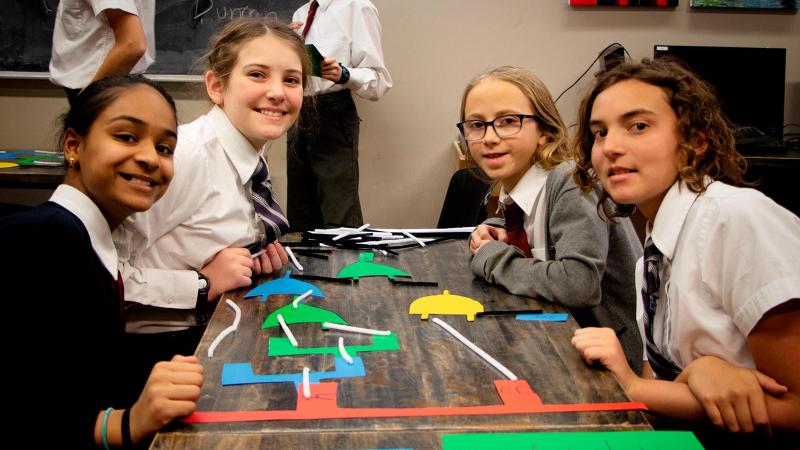 Picture of four students sitting at a class table around a school project