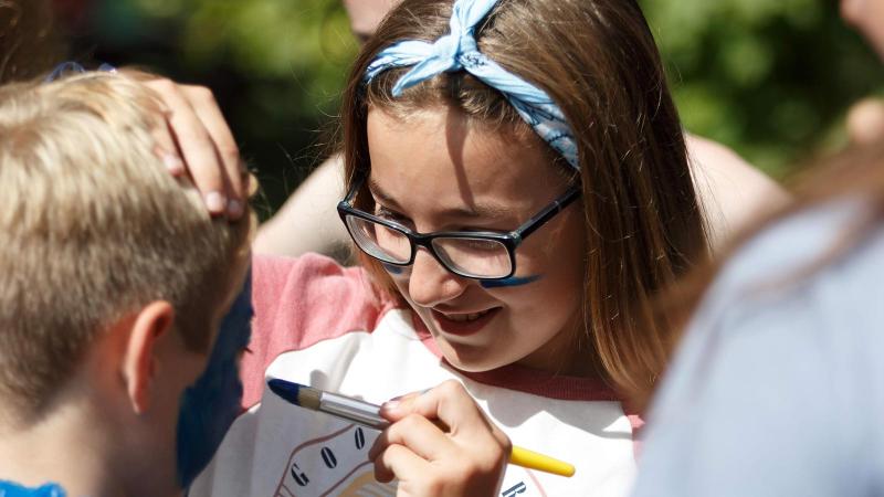 Picture of a student face painting on another student's face