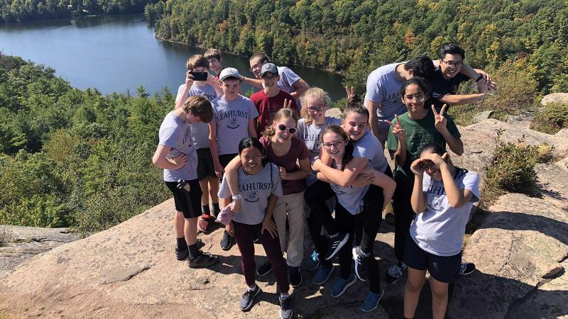 Picture of a group of student standing on the top of a mountain during a hiking activity