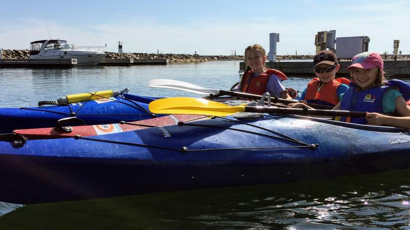 Picture of three students in kayaks on a lake