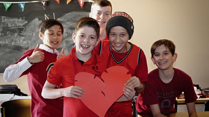 Picture of students holding a paper cut out of a red heart