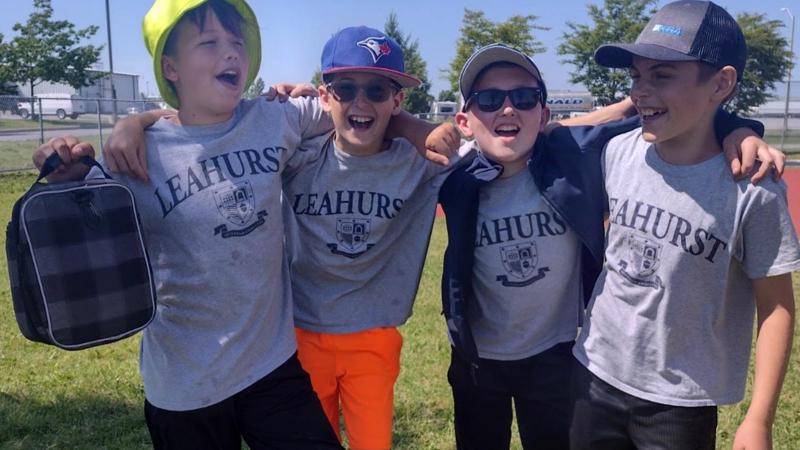 Picture of four students posing for a photo together outdoors