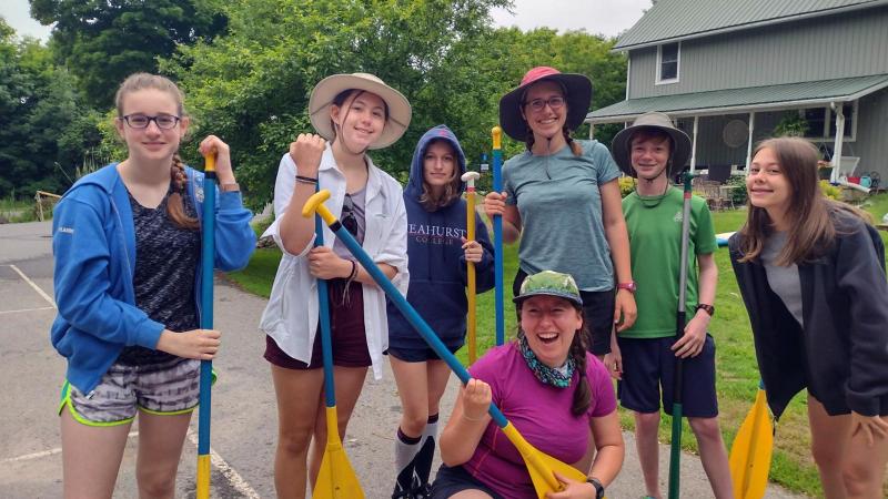 Picture of a group of students and faculty holding paddles