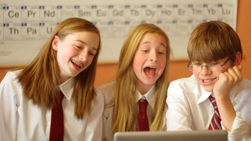 Picture of three student working around one computer together