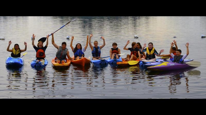 Picture of student in kayaks on a lake line up side by side for a photo