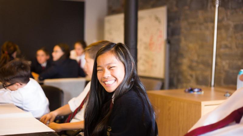 Picture of a student smiling in a classroom