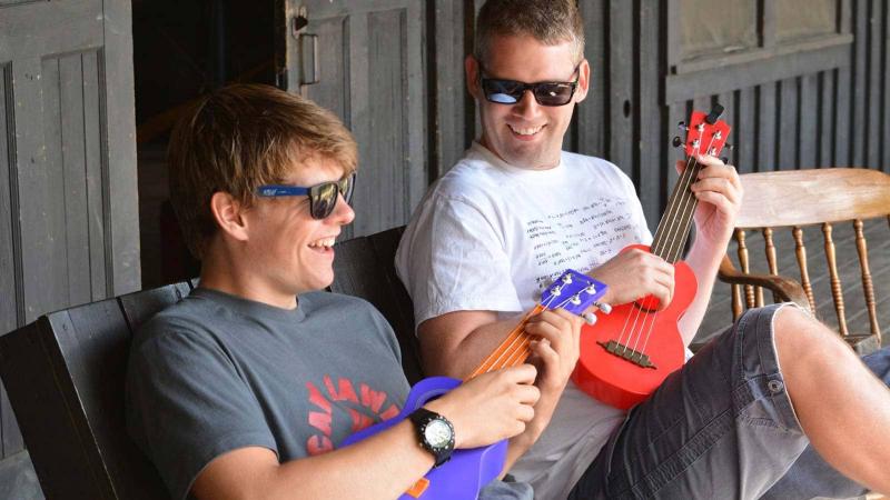 A teacher and student playing the ukulele