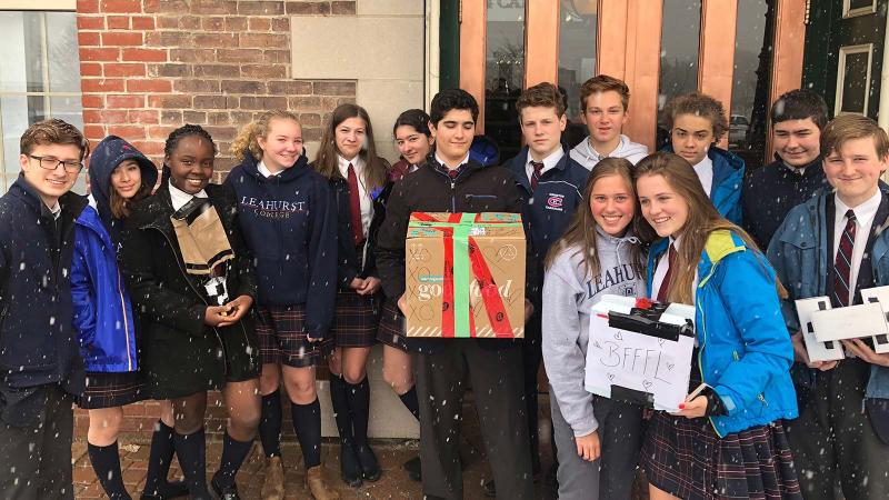 Picture of student holding up boxes for a food drive