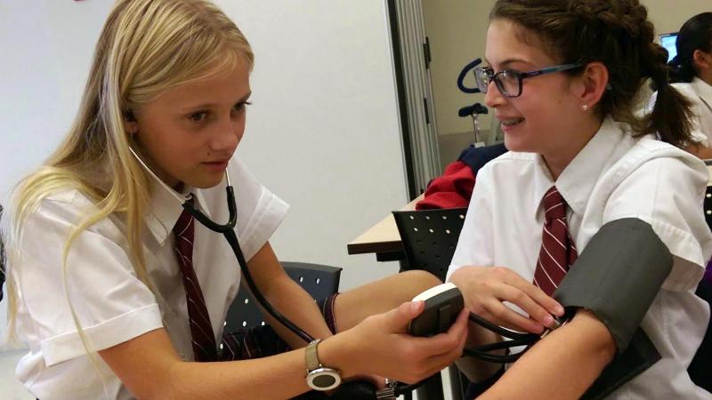 Picture of a student talking the blood pressure of another student during a field trip activity