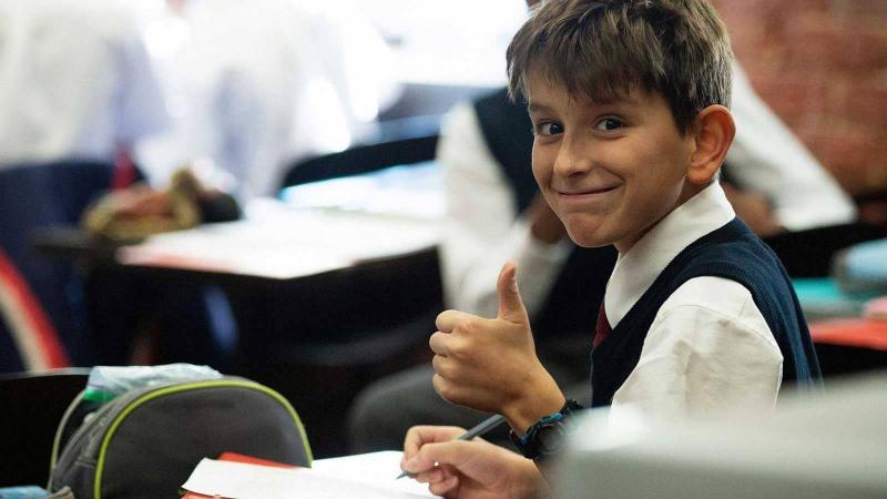 Picture of a student giving the thumbs up in class