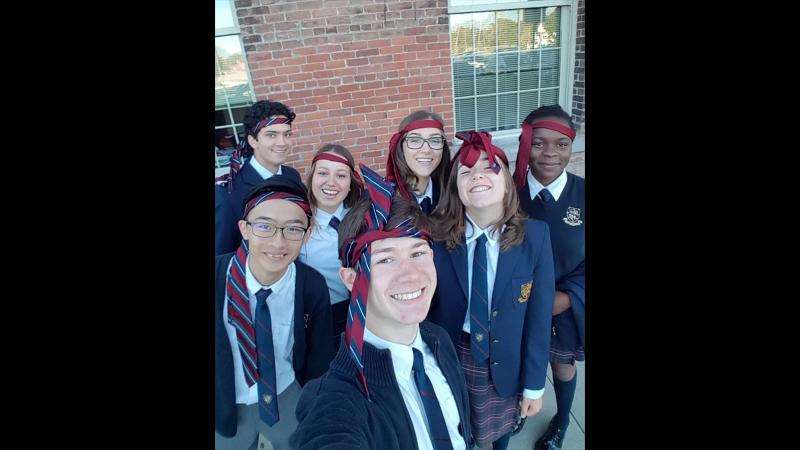 Picture of seven students taking a selfie with ties around their heads