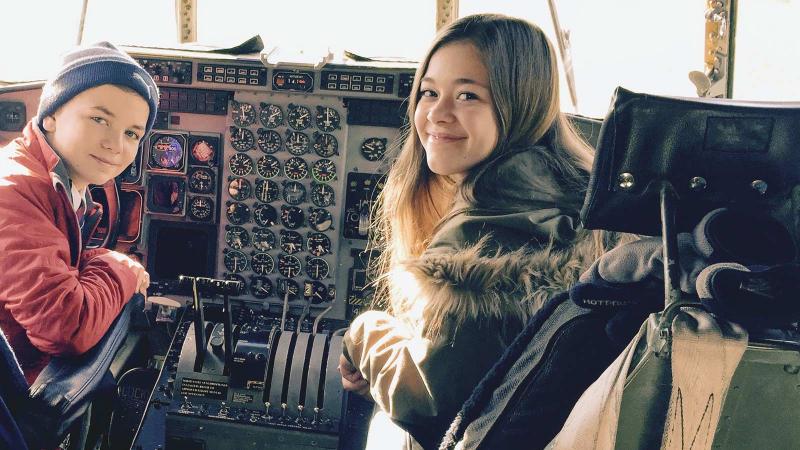 Picture of two student sitting in the cockpit of an airplane